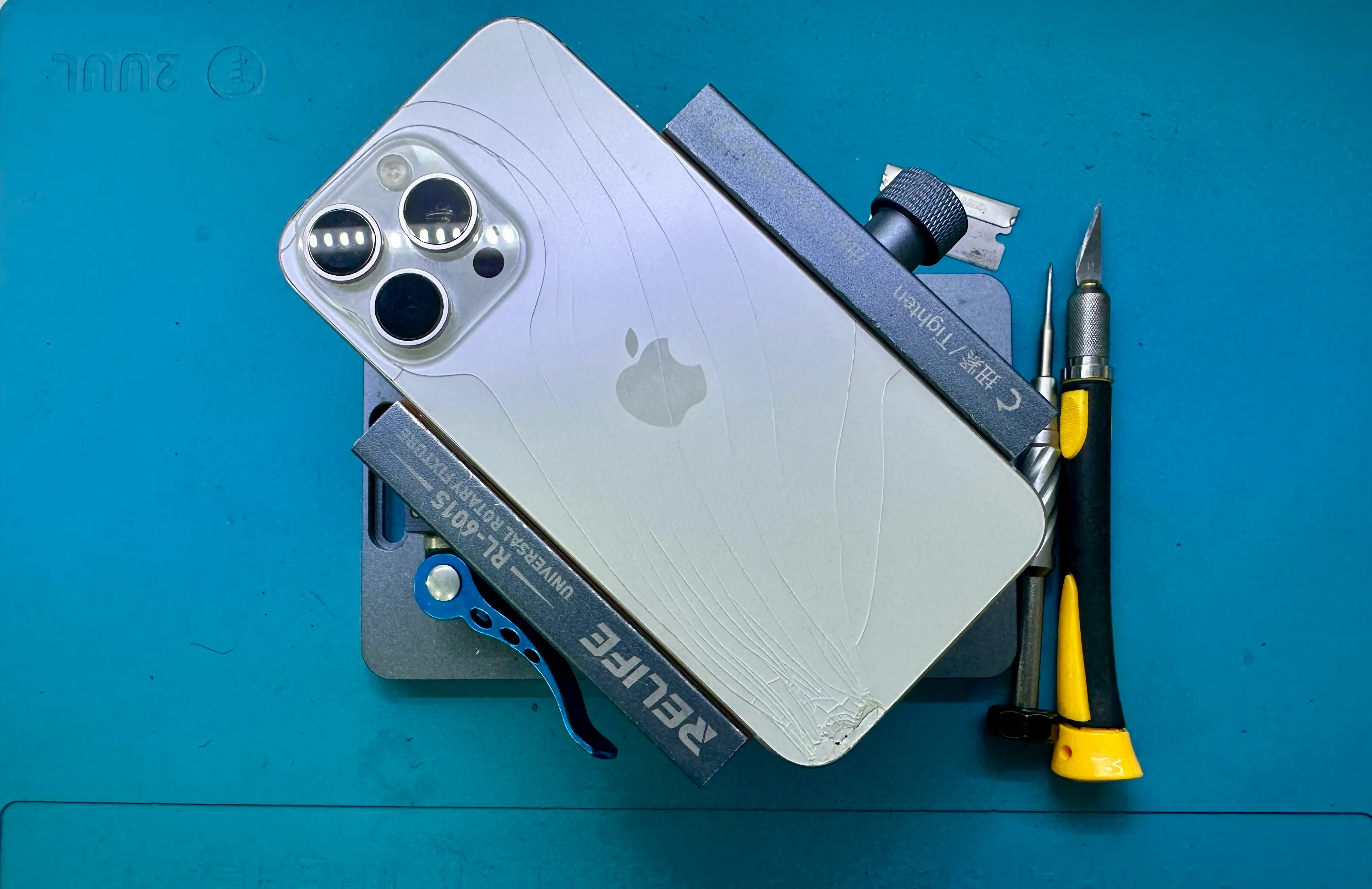 MycelCare technician performing iPhone back glass replacement using laser separator and precision tools